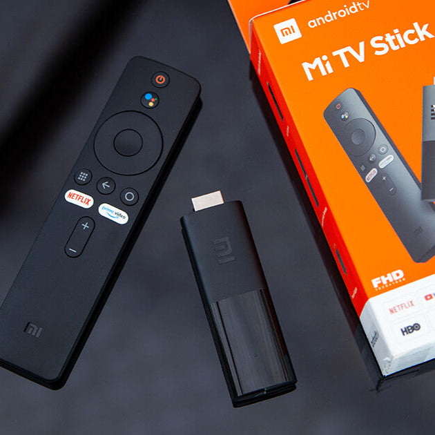Mi TV Stick with remote control and packaging on a dark background